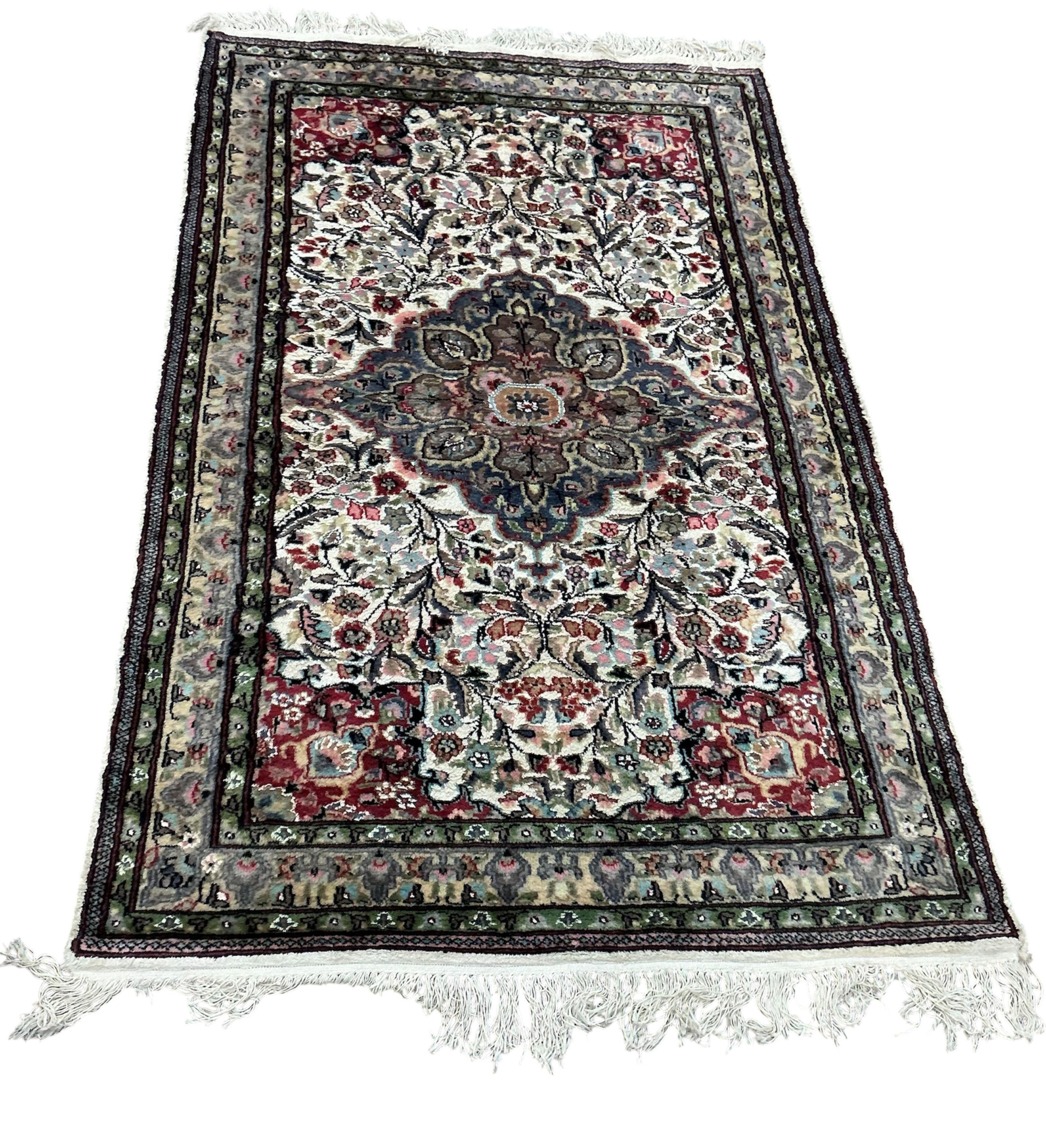 A Pakistan ivory ground part silk medallion rug, 196cm x 125cm